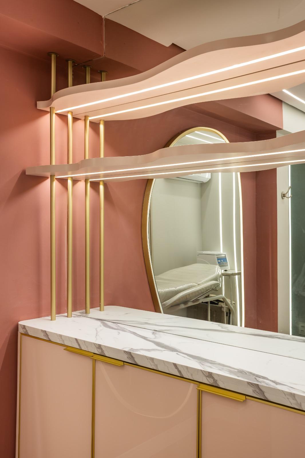 Detalhe de prateleiras em latão com espelho refletindo a maca — Edna Designer