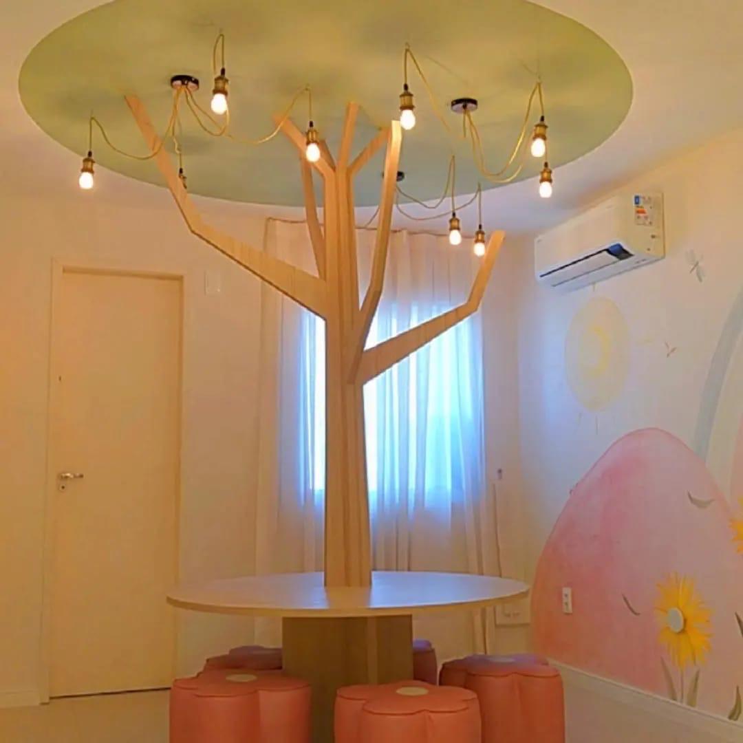 Espaço kids com árvore decorativa suspensa e pufes florais — Edna Designer